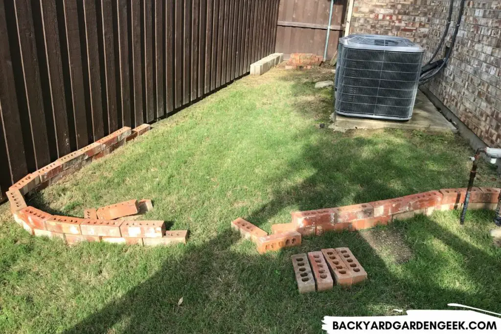 bricks laying in a border of what may become a raised garden bed